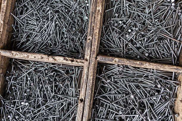 Molti acciaio chiodi in scatole di legno. - foto stock