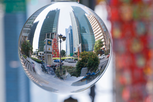 Singapore, Singapore - May 26, 2015: Reflection of skyscrapers in Central Business District of Singapore during daytime, showing busy vehicle traffic.