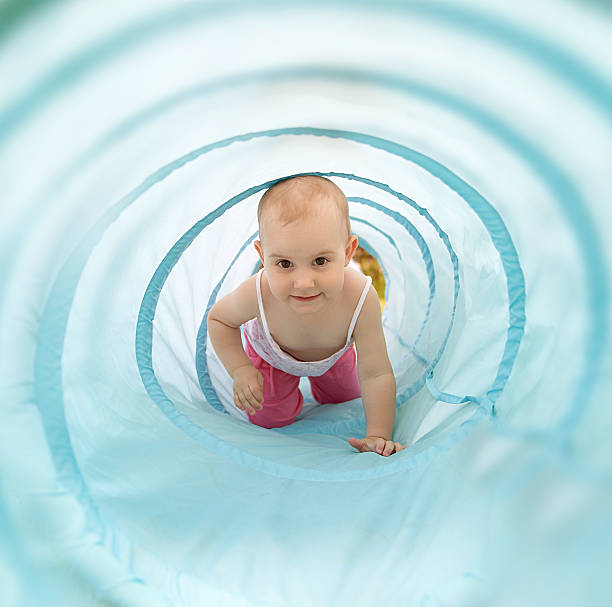 istock Baby playing inside a toy tunnel 476210317