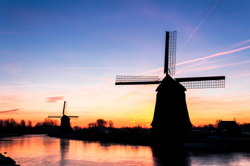 Beautiful winter sunrise in Alkmaar in Netherlands. Silhouettes of Dutch windmills can be seen on this photo.