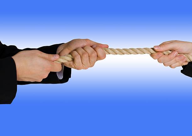 tug of war with blue background tug of war between business people with blue background vinner stock pictures, royalty-free photos & images