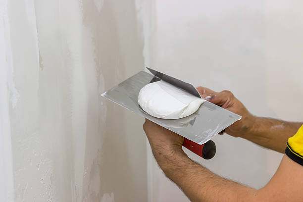 Mixing skimming plaster on trowel 2 Mixing skimming plaster on trowel for the patching hand with a plaster spatula stock pictures, royalty-free photos & images