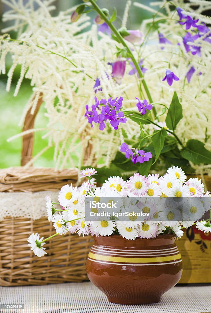 Bouquet di fiori selvatici in un vaso sul tavolo - Foto stock royalty-free di Ambientazione esterna