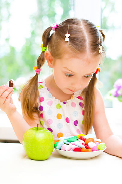 istock girl with apple and  sweets 476219669