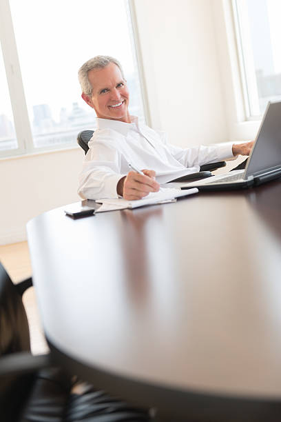istock Happy Businessman Writing On Document At Desk 476219861