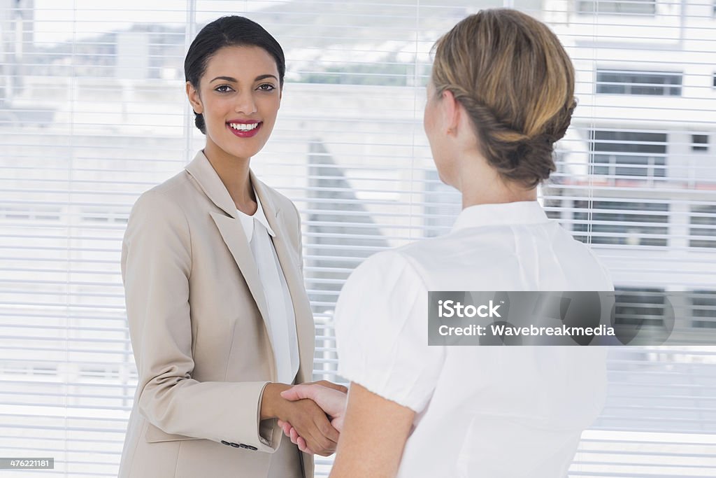 Alegre socios de negocios estrechándose las manos - Foto de stock de A la moda libre de derechos