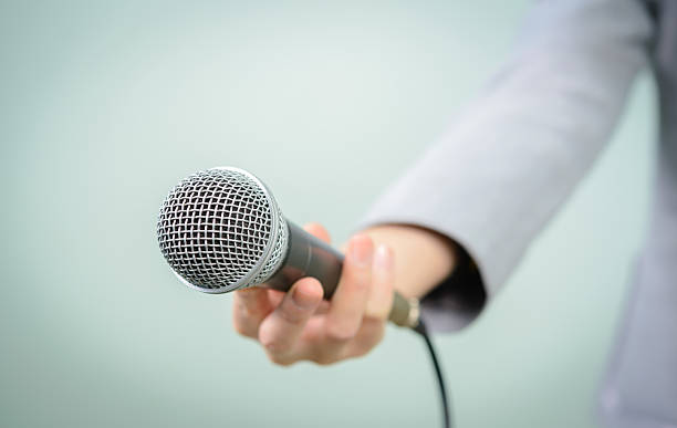 istock female with microphone, close up 476222706