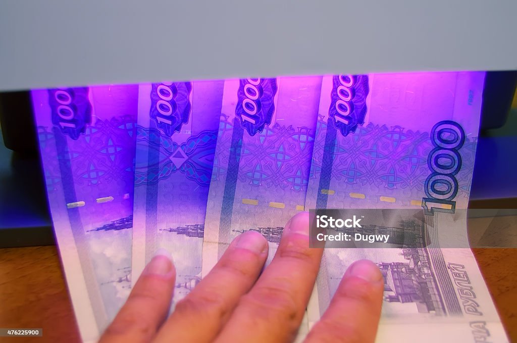 Money Checking of banknotes using ultraviolet of detector Currency Stock Photo