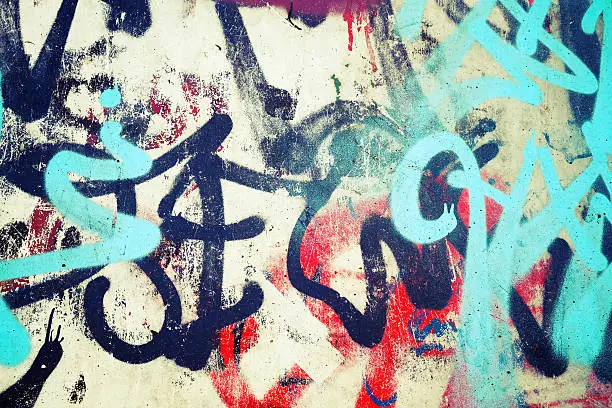 Abstract colorful graffiti patterns over old urban concrete wall, vintage tonal photo filter effect, retro style