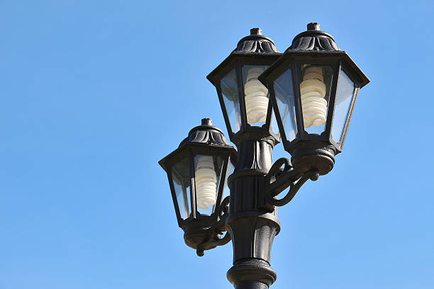 istock Three vintage street lamps against bright blue sky 476227352