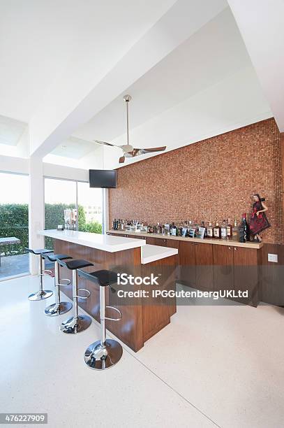 Bar Counter And Bottles With High Ceiling Stock Photo - Download Image Now - Bar Counter, Ceiling Fan, Indoors