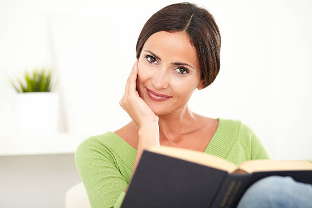 istock Smiling young woman holding a book 476227952