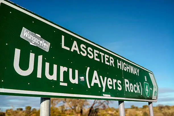 A road sign showing the direction to Uluru along the long-stretching Lasseter Highway.