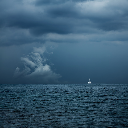 Boat Sailing in Center of Storm Formation. Dramatic Background. Danger in Sea Concept. Toned Photo with Copy Space.