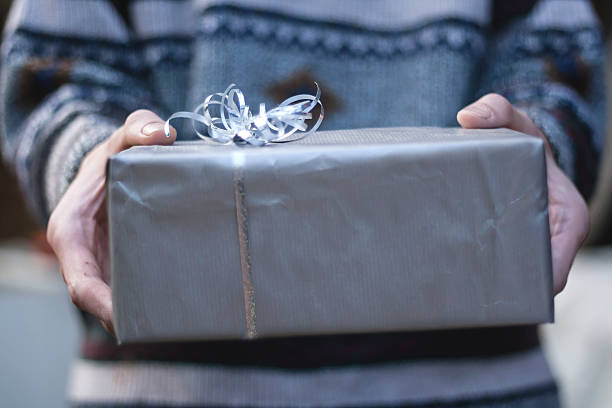 istock male hands offering a christmas gift 476232444