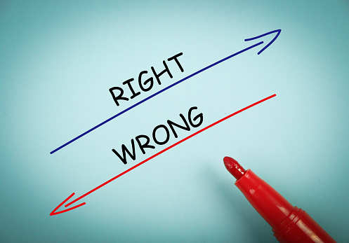 Right and wrong concept is on blue paper with a red marker aside.