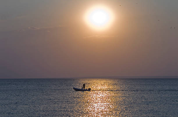 istock man relaxing on a boat at Sunset 476234975