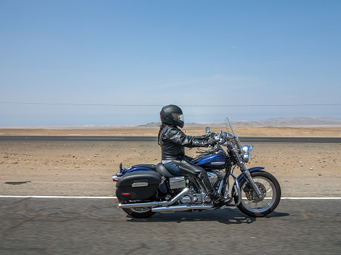 Huaral, Peru - January 22, 2015: Harley Davidson female Motorcyclist on the pan-american highway in Peru