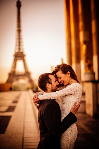 Photo of young married couple in front of an Eiffel tower