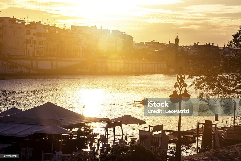 Riva del fiume a piedi al tramonto a Siviglia - Foto stock royalty-free di Acqua