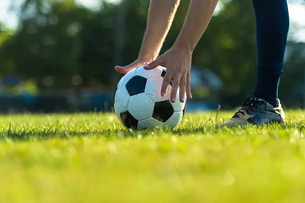 Close-up of black and white soccer ball positioning for the free kick