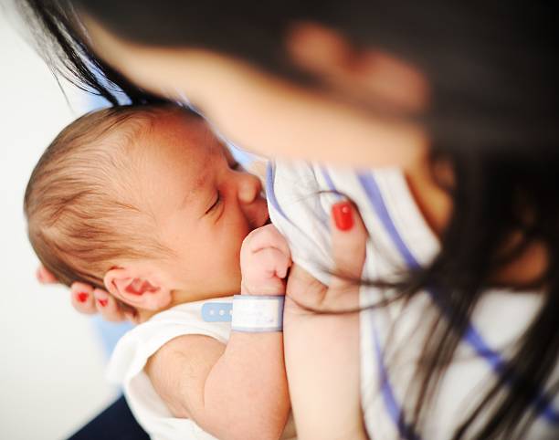 madre allattando il suo neonato - sucking asian ethnicity baby mother foto e immagini stock