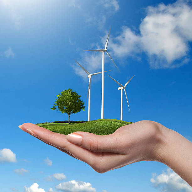 istock Wind turbines with tree in female hand 476245694