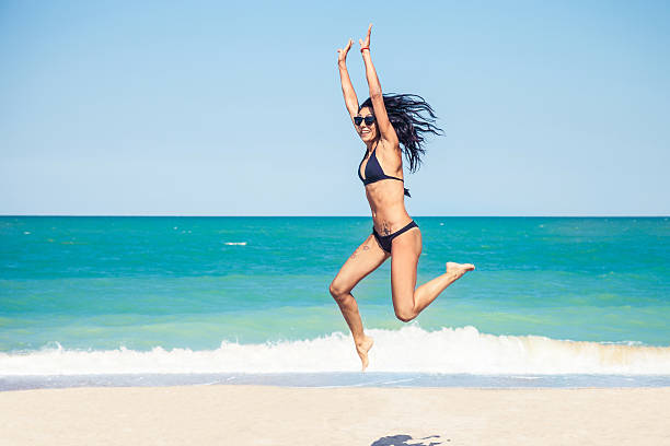 istock Happy woman jumping on the beach 476247987