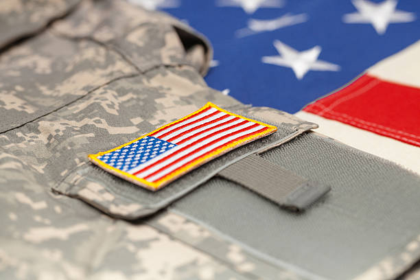 istock USA flag with army uniform over it - studio shot 476248134