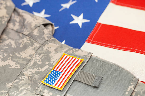 istock USA flag with US army uniform - studio shot 476248136