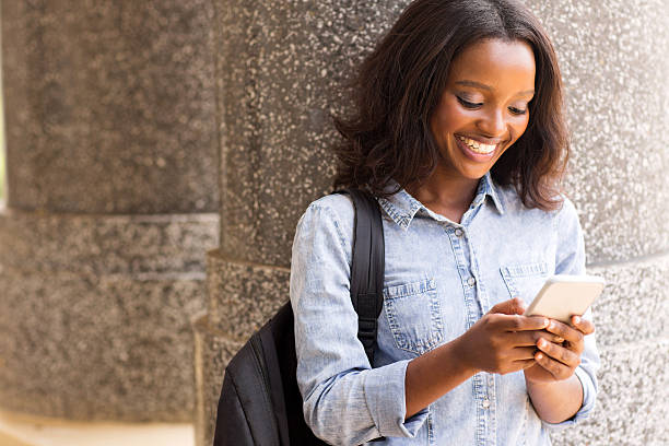 istock female afro american university student using cell phone 476249280