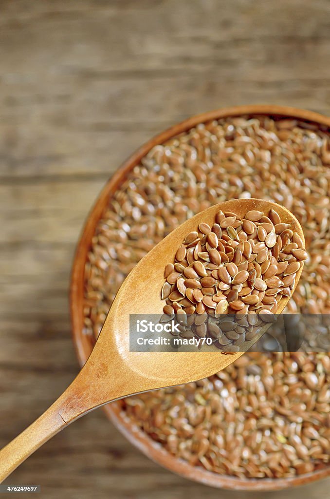 close up of flax seeds and wooden spoon close up of flax seeds and wooden spoon on wood background; dietary supplement Brown Stock Photo