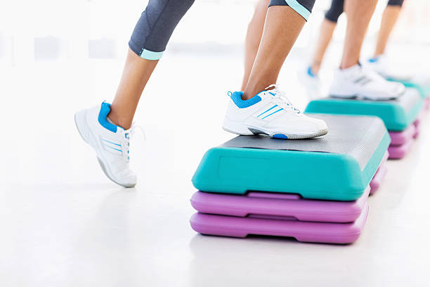 istock Friends Doing Aerobics Using Stair Stepper In Gym 476250099