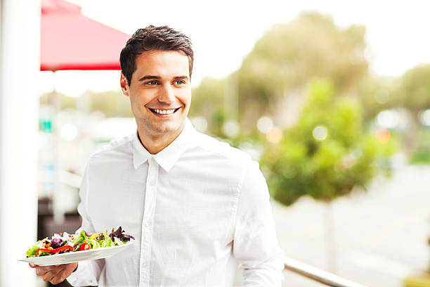 istock Waiter Looking Away While Holding Salad In Restaurant 476250227
