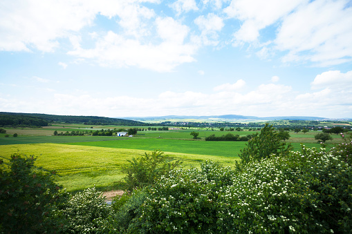Meadows, field and hills of eastern outskirts of Taunus seen from A 5 in northeast of Frankfurt at sunny day.