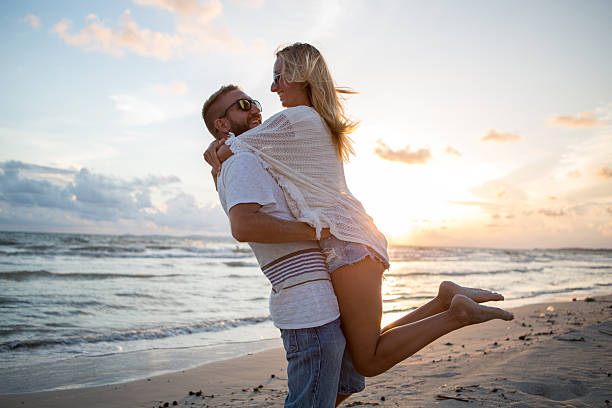 istock Young couple celebrating their love on beach at sunset 476255902