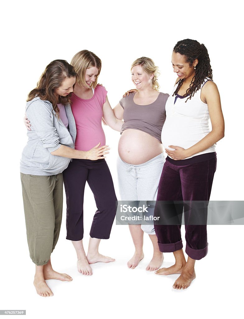 Can I feel it kicking? Pregnant friends standing together while isolated on white 25-29 Years Stock Photo