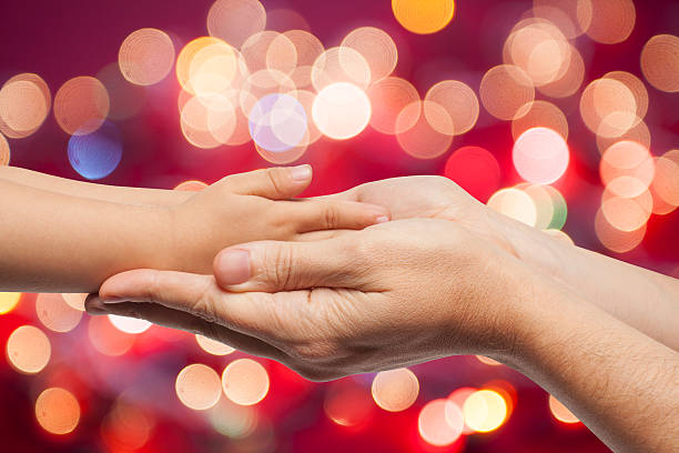 istock father and son holding hands on christmas lights background 476258532