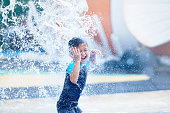 Cute asian boy playing at waterpark