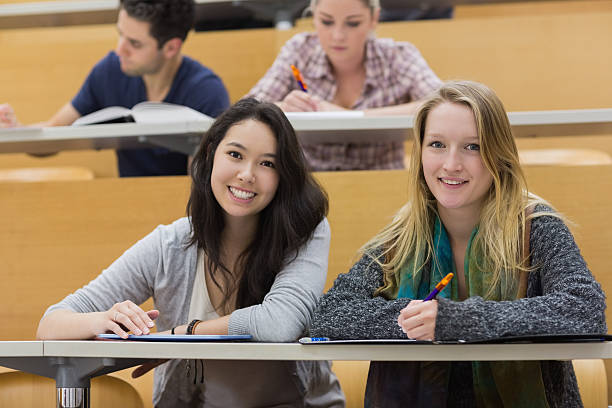 istock Girls smiling in lecture hall with tablet pc 476262028