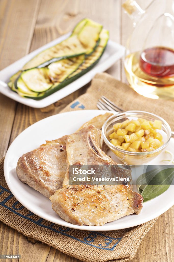 Pork cutlets on a bone with apple chutney Pork cutlets on a bone with apple and raisin chutney and grilled zucchini Animal Bone Stock Photo