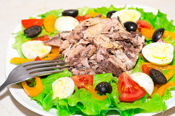 Tuna salad canned fish mixed green leaf lettuce seafood appetizer vegetable dish organic fresh tasty gourmet food background on the table rustic top view copy space vegetarian food pescetarian diet