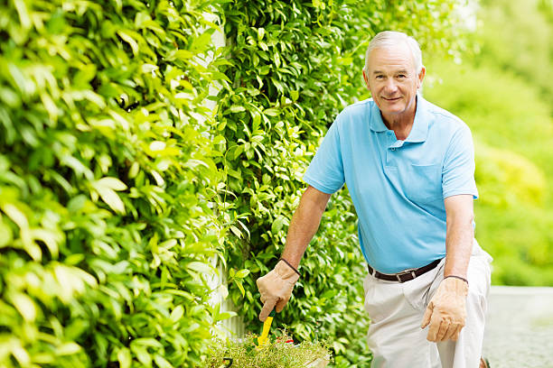 Confident Senior Man Holding Shovel While Gardening