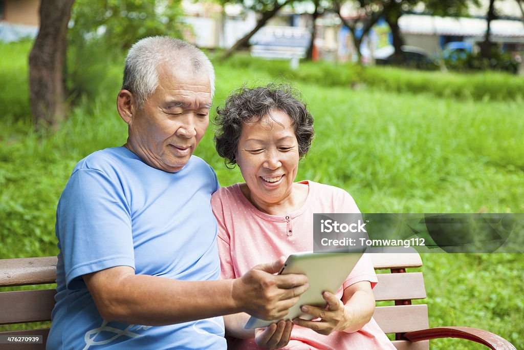 Heureux couple de personnes âgées avec tablette dans le parc - Photo de Adulte libre de droits