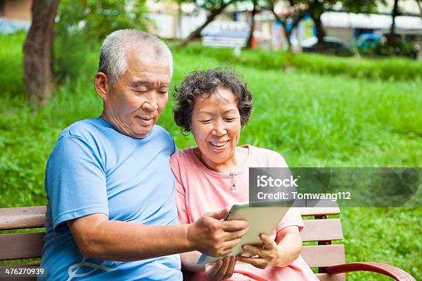 Photo libre de droit de Heureux Couple De Personnes Âgées Avec Tablette Dans Le Parc banque d'images et plus d'images libres de droit de Adulte