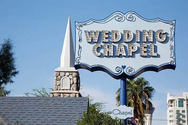 Wedding chapel sign in Las Vegas. In the background a false bell tower.