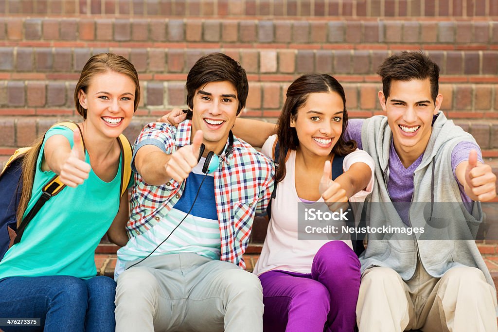 Gruppo di studenti universitari fare gesti pollice in alto insieme su Campus - Foto stock royalty-free di Felicità