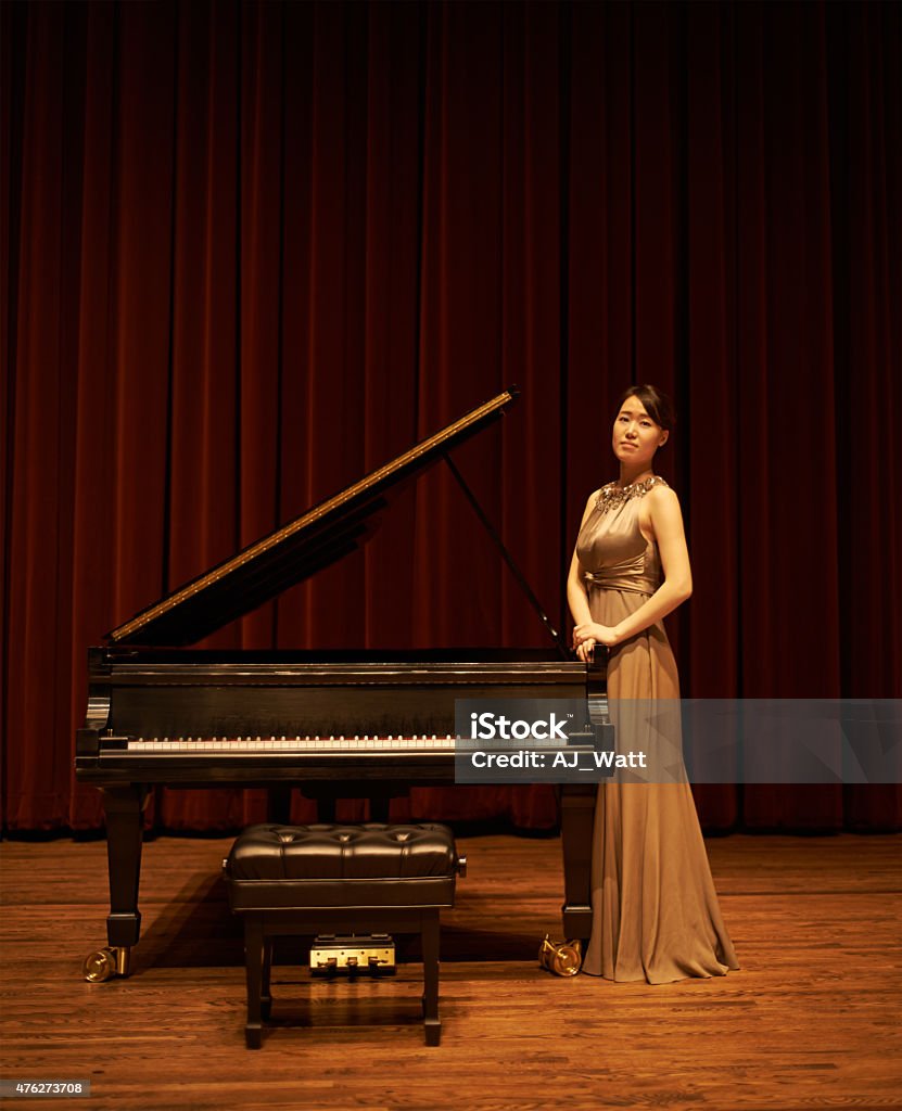 She's the main attraction Shot of a young woman standing by her piano at the end of a musical concerthttp://195.154.178.81/DATA/i_collage/pu/shoots/804836.jpg 20-29 Years Stock Photo