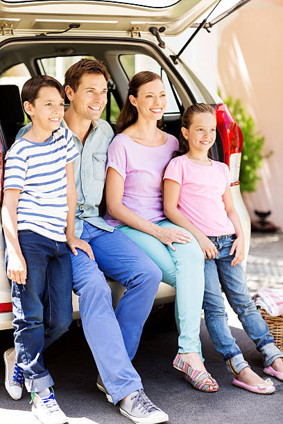 istock Smiling Family Looking Away While Sitting In Car Trunk 476274012