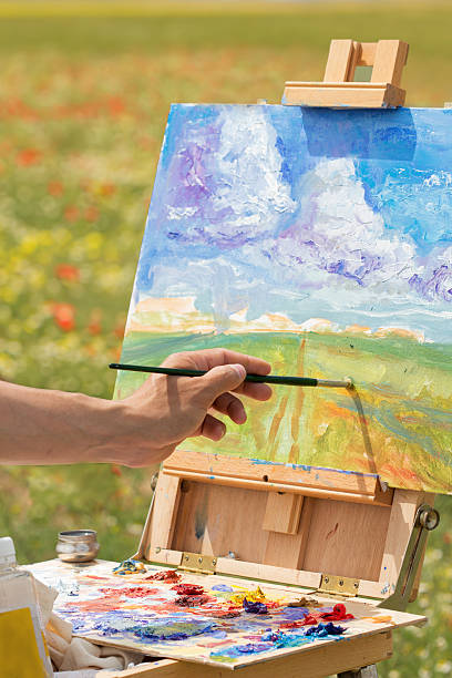 istock artist hand paints with brush on nature 476277932